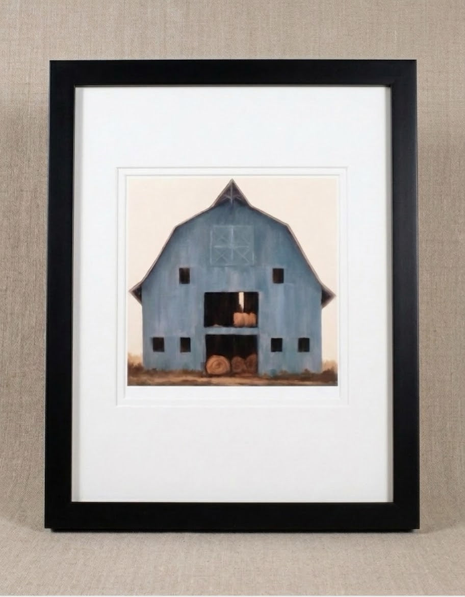 Country Living blue barn with rolls of hay