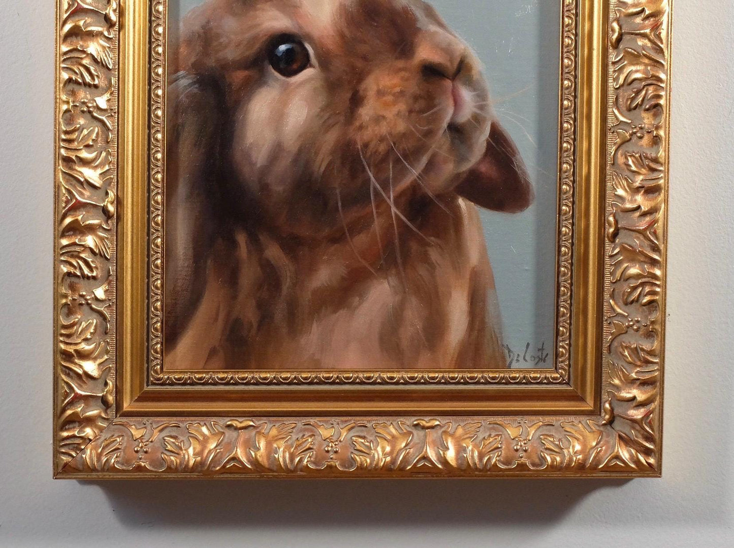 Coco bunny with the blue background in ornate gold frame